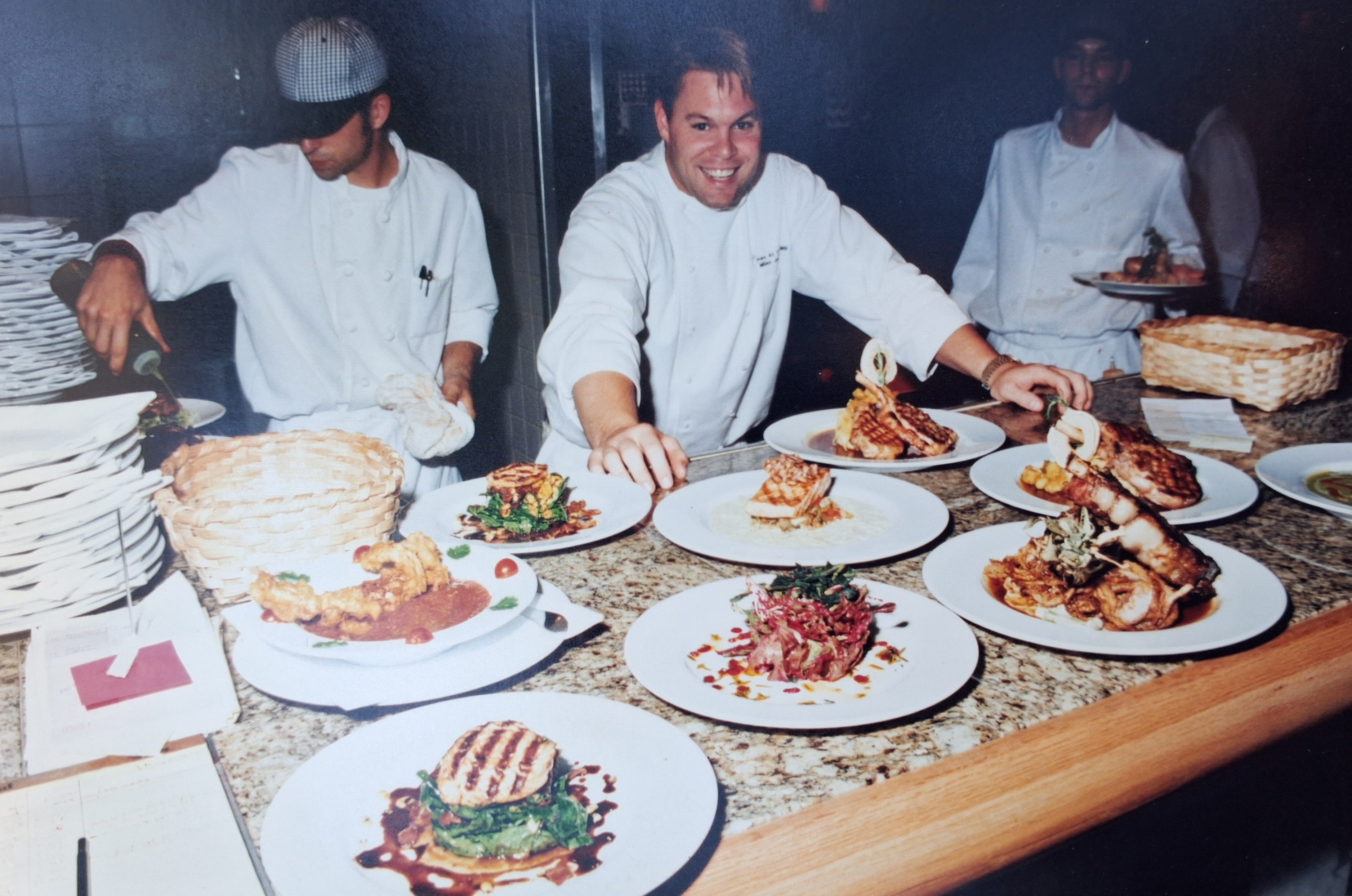 Chefs preparing plates in the restaurant kitchen.